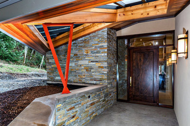 Inspiration for a large contemporary concrete floor entryway remodel in Seattle with beige walls and a dark wood front door