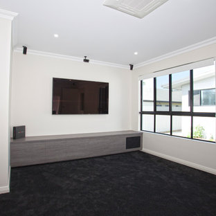 Mid-sized minimalist enclosed carpeted home theater photo in Brisbane with white walls and a wall-mounted tv