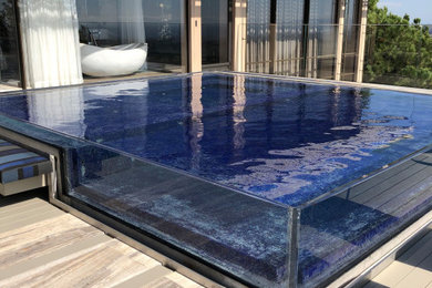 Imagen de piscina infinita moderna extra grande a medida en azotea con paisajismo de piscina y suelo de baldosas