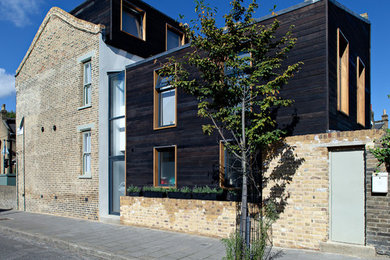 Contemporary three-storey exterior in London with wood siding.