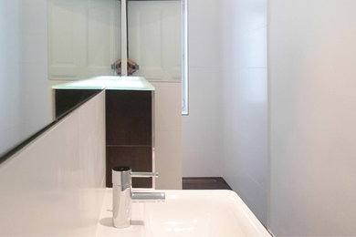 Kleines Modernes Badezimmer mit Wandtoilette mit Spülkasten, schwarz-weißen Fliesen, Keramikfliesen, weißer Wandfarbe und Keramikboden in Berlin