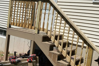 Deck - mid-sized traditional side yard ground level wood railing deck idea in Other with no cover