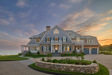Beach style beige three-story wood and shingle house exterior photo in New York with a gambrel roof, a shingle roof and a gray roof
