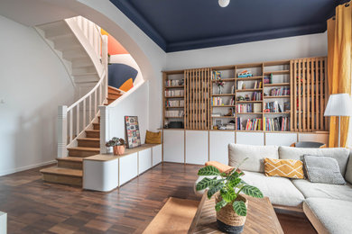 Cette image montre un salon design ouvert avec un mur blanc, parquet foncé et un sol marron.