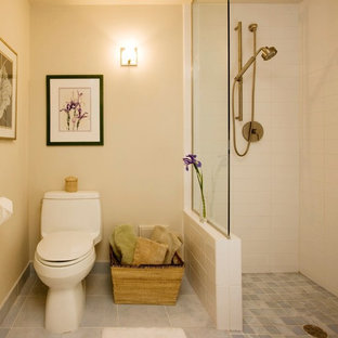 Kleines Klassisches Duschbad mit bodengleicher Dusche, Toilette mit Aufsatzspülkasten, weißen Fliesen, Metrofliesen, beiger Wandfarbe, Porzellan-Bodenfliesen, grauem Boden und offener Dusche in Milwaukee