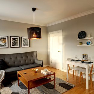 Minimalistisk inredning av en liten matplats med öppen planlösning, med grå väggar, ljust trägolv och gult golv