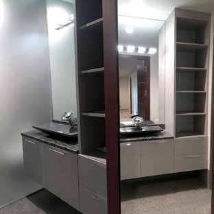 Example of a mid-sized minimalist mirror tile porcelain floor and gray floor bathroom design in Chicago with flat-panel cabinets, gray cabinets, a wall-mount toilet, white walls, a vessel sink, quartz countertops and a hinged shower door