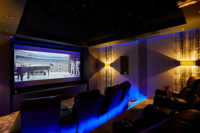 Inspiration for a large contemporary enclosed home theatre in West Midlands with grey walls, carpet, a projector screen and grey floor.