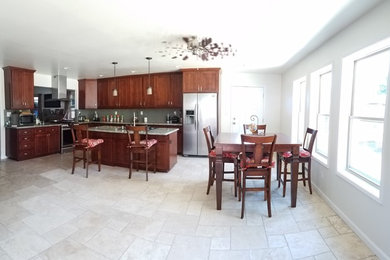 Inspiration for a large timeless l-shaped limestone floor open concept kitchen remodel in Los Angeles with an undermount sink, shaker cabinets, dark wood cabinets, granite countertops, gray backsplash, stainless steel appliances and an island
