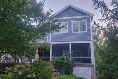 Large arts and crafts screened-in and mixed material railing back porch idea in St Louis with a roof extension