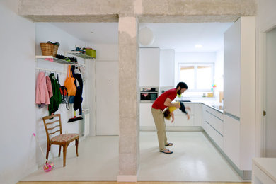 Foto de cocinas en L actual de tamaño medio abierta sin isla con fregadero de un seno, armarios con paneles lisos, puertas de armario blancas, salpicadero blanco, electrodomésticos blancos, suelo de cemento y microcemento
