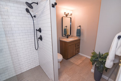 Alcove shower - mid-sized cottage white tile and subway tile cement tile floor, beige floor and single-sink alcove shower idea in Cincinnati with flat-panel cabinets, brown cabinets, a one-piece toilet, beige walls, an undermount sink, quartz countertops, a hinged shower door, beige countertops and a floating vanity