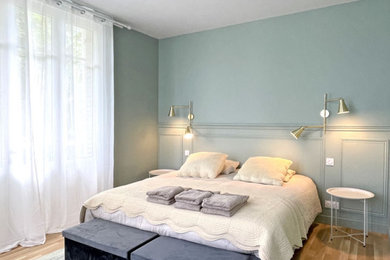 Exemple d'une chambre parentale chic de taille moyenne avec un mur vert, parquet clair, aucune cheminée et un sol beige.