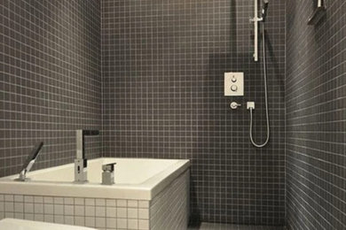 Trendy gray tile freestanding bathtub photo in Other with a two-piece toilet
