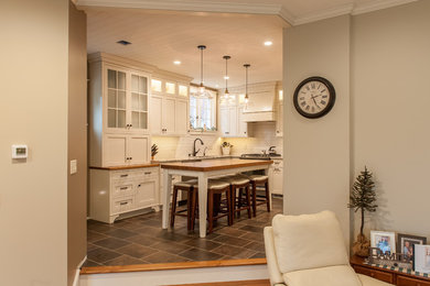 Inspiration for a mid-sized farmhouse u-shaped ceramic tile and brown floor eat-in kitchen remodel in Other with a single-bowl sink, shaker cabinets, white cabinets, granite countertops, white backsplash, ceramic backsplash, an island and multicolored countertops