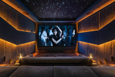 Imagen de cine en casa cerrado contemporáneo de tamaño medio con paredes grises, moqueta, pantalla de proyección y suelo gris