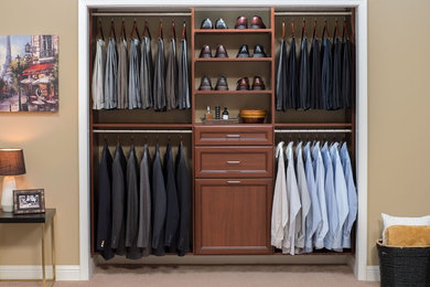 This is an example of a small transitional men's built-in wardrobe in Denver with carpet, recessed-panel cabinets and medium wood cabinets.