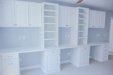 Example of a classic built-in desk carpeted home office design in Raleigh with blue walls