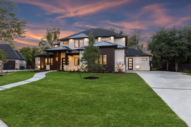 Inspiration for a large modern white two-story stucco exterior home remodel in Dallas with a metal roof and a black roof