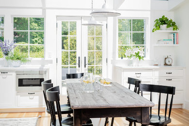 Kitchen/dining room combo - coastal medium tone wood floor and beige floor kitchen/dining room combo idea in Boston with white walls