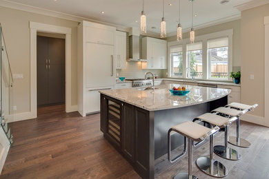 This is an example of a large contemporary open plan kitchen in Vancouver with an undermount sink, flat-panel cabinets, white cabinets, glass tile splashback, stainless steel appliances, medium hardwood floors and with island.