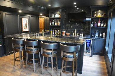 Seated home bar - large transitional u-shaped medium tone wood floor and brown floor seated home bar idea in DC Metro with an undermount sink, recessed-panel cabinets, black cabinets, quartz countertops, black backsplash, quartz backsplash and black countertops