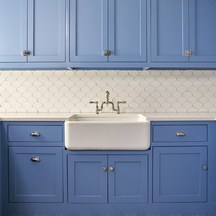 ダラスの中サイズのトランジショナルスタイルのおしゃれな洗濯室 (エプロンフロントシンク、シェーカースタイル扉のキャビネット、青いキャビネット、白い壁、青い床、白いキッチンカウンター、人工大理石カウンター、セラミックタイルの床) の写真
