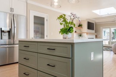 Inspiration for a transitional l-shaped light wood floor open concept kitchen remodel in San Francisco with an undermount sink, shaker cabinets, green cabinets, white backsplash, stainless steel appliances, an island, quartzite countertops, ceramic backsplash and white countertops