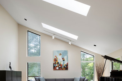 Example of a huge trendy open concept light wood floor and brown floor family room design in New York with a music area, no tv, white walls and no fireplace