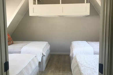 Example of a beach style loft-style light wood floor and gray floor bedroom design in Little Rock with gray walls