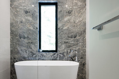 Inspiration for a mid-sized contemporary master bathroom in Montreal with a freestanding tub, a shower/bathtub combo, grey walls, marble floors, grey floor and an open shower.