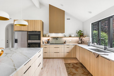Inspiration for a mid-sized modern l-shaped light wood floor and beige floor eat-in kitchen remodel in Chicago with an undermount sink, flat-panel cabinets, light wood cabinets, stainless steel appliances and an island