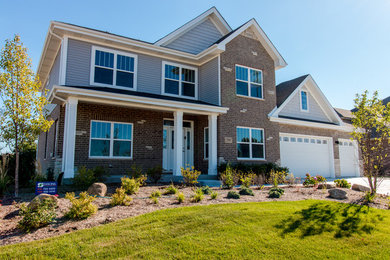 Huge traditional brown two-story mixed siding exterior home idea in Chicago with a clipped gable roof