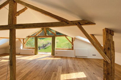 Offenes, Geräumiges Landhausstil Wohnzimmer mit weißer Wandfarbe und braunem Holzboden in Sonstige