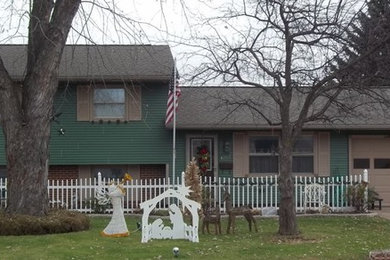 Example of a classic green one-story exterior home design in Cleveland with a gambrel roof