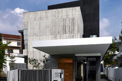 Example of a trendy three-story mixed siding flat roof design in Singapore