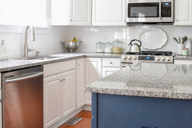 Example of a large transitional l-shaped medium tone wood floor and orange floor eat-in kitchen design in Nashville with an undermount sink, raised-panel cabinets, white cabinets, granite countertops, white backsplash, ceramic backsplash, stainless steel appliances, an island and gray countertops