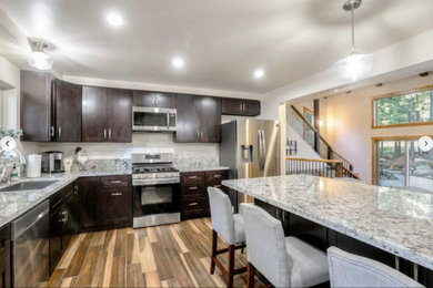 Inspiration for a kitchen remodel in Sacramento with a single-bowl sink, shaker cabinets, dark wood cabinets, granite countertops, stainless steel appliances, an island and gray countertops