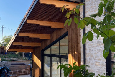 Réalisation d'une façade de maison design à deux étages et plus avec un revêtement mixte, un toit en tuile et un toit rouge.