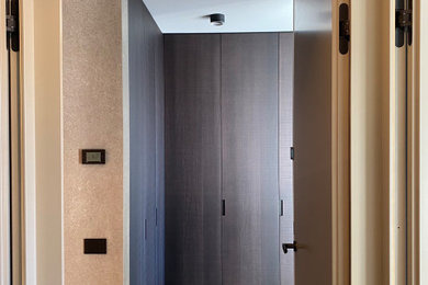 Mittelgroßes Modernes Ankleidezimmer mit Ankleidebereich, flächenbündigen Schrankfronten, dunklen Holzschränken, braunem Holzboden und braunem Boden