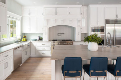 Inspiration for a mid-sized contemporary l-shaped medium tone wood floor eat-in kitchen remodel in Seattle with an undermount sink, shaker cabinets, white cabinets, quartz countertops, stainless steel appliances and an island