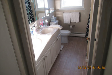 Inspiration for a small timeless master beige tile and porcelain tile porcelain tile alcove bathtub remodel in Philadelphia with raised-panel cabinets, white cabinets, a two-piece toilet, beige walls, an integrated sink and solid surface countertops