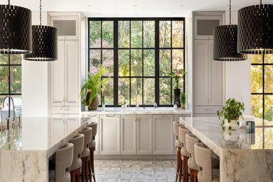 Enclosed kitchen - huge mediterranean u-shaped ceramic tile, beige floor and wood ceiling enclosed kitchen idea in New York with an undermount sink, recessed-panel cabinets, white cabinets, marble countertops, beige backsplash, marble backsplash, stainless steel appliances, two islands and beige countertops