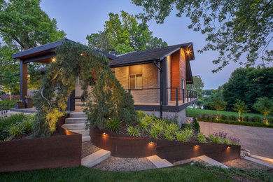 This is an example of a mid-sized mid-century modern partial sun front yard decomposed granite and metal fence landscaping in Detroit.