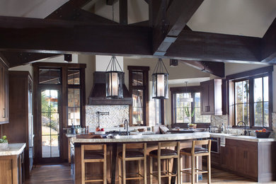 Inspiration for a large country u-shaped separate kitchen in Denver with an undermount sink, shaker cabinets, dark wood cabinets, quartzite benchtops, beige splashback, stone tile splashback, stainless steel appliances, dark hardwood floors, with island and brown floor.