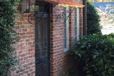 Example of a mid-sized classic brown one-story brick gable roof design in Atlanta