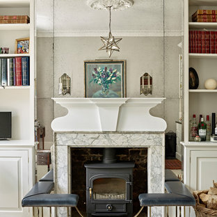 Traditional living room in London with beige walls, dark hardwood flooring, a wood burning stove, a stone fireplace surround and black floors.