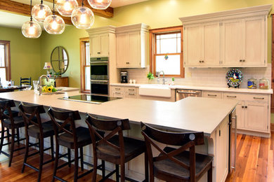 This is an example of an expansive country eat-in kitchen in Atlanta with a farmhouse sink, recessed-panel cabinets, green cabinets, marble benchtops, grey splashback, ceramic splashback, stainless steel appliances, medium hardwood floors, with island and brown floor.