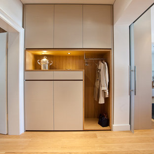 Modern inredning av en hall, med ljust trägolv och beige väggar
