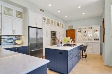 Eat-in kitchen - large contemporary u-shaped travertine floor, beige floor and vaulted ceiling eat-in kitchen idea in Other with an undermount sink, shaker cabinets, white cabinets, quartz countertops, blue backsplash, glass tile backsplash, stainless steel appliances, an island and white countertops